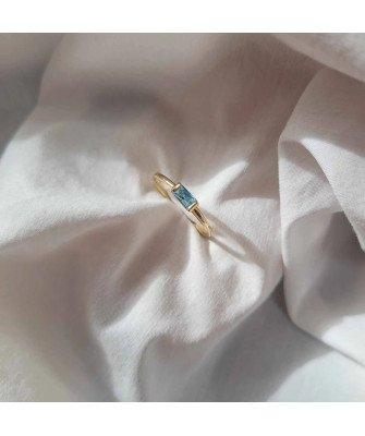 Delicate gold ring with a light blue stone